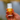 Hand holding a roll-on bottle of Camo insect repellent against a blurred natural background.