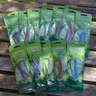 A collection of individually packed leather mosquito repellent wristbands displayed on a wooden surface, with green packaging featuring the camo brand.