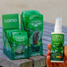 Camo insect repellent packaging on a wooden surface and a bottle held by a hand.